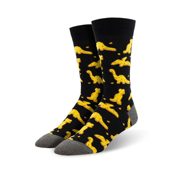 Pair of black crew socks with a fun pattern of yellow dinosaur nuggets.  Comfortable and playful! }}