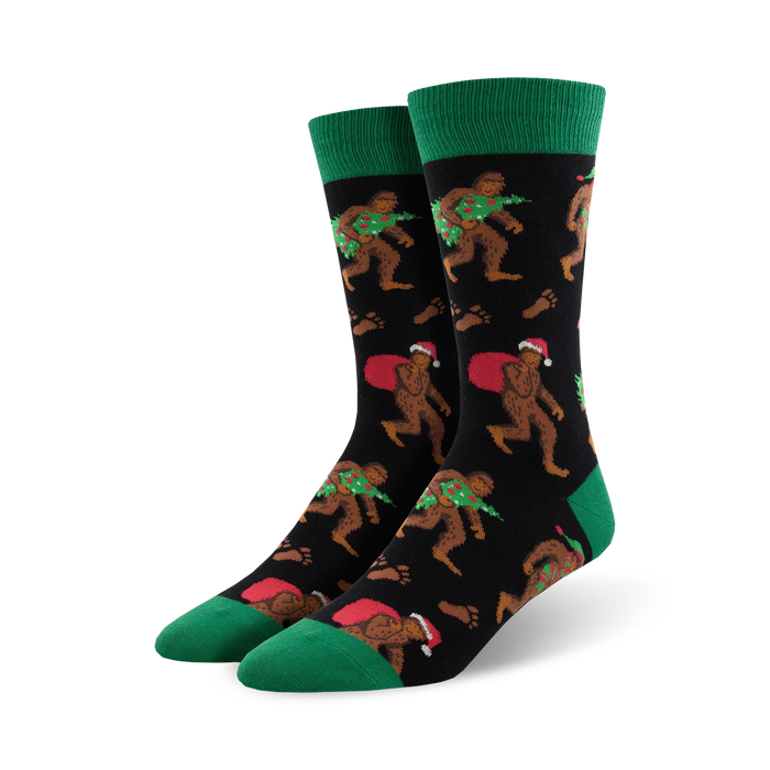 mens crew socks with christmas bigfoot pattern, santa hat, presents, wreath, black, green.     }}