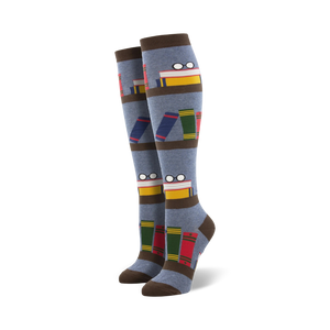 Pair of blue knee-high socks with a bookshelf design. Books, glasses, and brown stripes are featured on a grey-blue background.