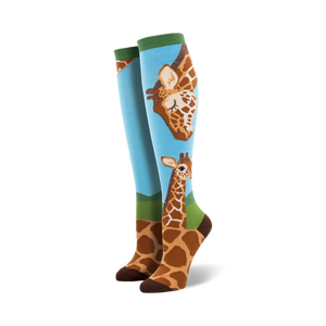 Pair of knee-high socks; light blue background, brown giraffes, green accents. Adult sized.