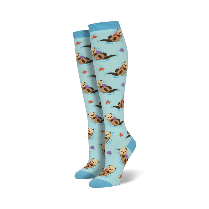 light blue women's knee-high socks, all over pattern of cartoon otters swimming in water, and holding purple starfish    }}