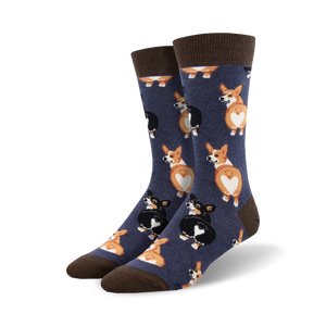 Close-up view of a pair of navy blue crew socks with a pattern of corgi butts. The socks have brown cuffs.