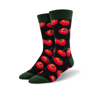 Close-up view of Toe-May-Toes socks with red tomatoes on a black background, showing the detail of the tomato pattern.