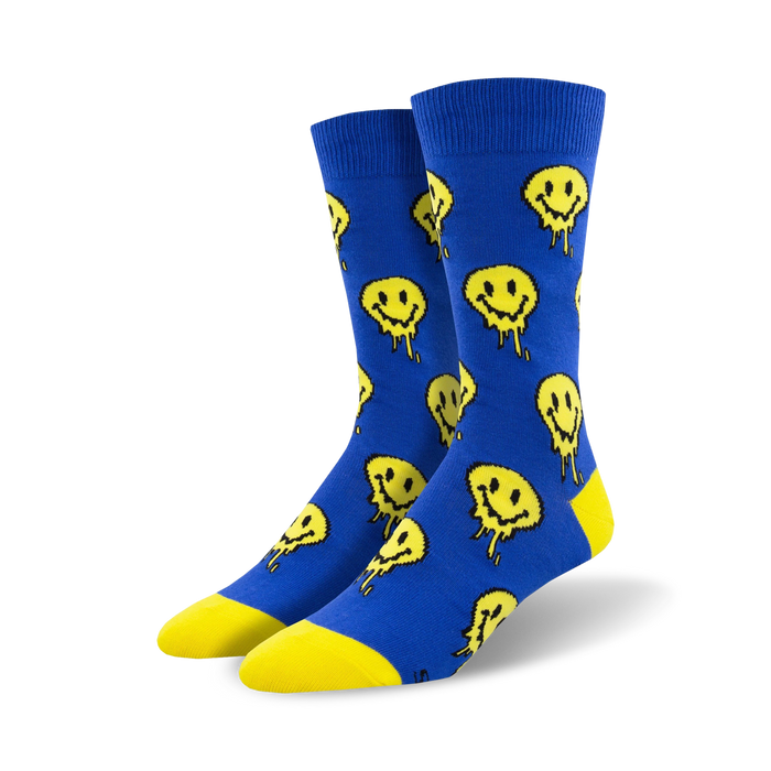 Pair of blue crew socks with a pattern of yellow melting smiley faces.  The socks have a yellow heel and toe. }}