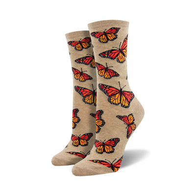 Pair of women's crew socks. Beige and orange monarch butterflies are printed on a light beige background. Fun and colorful.