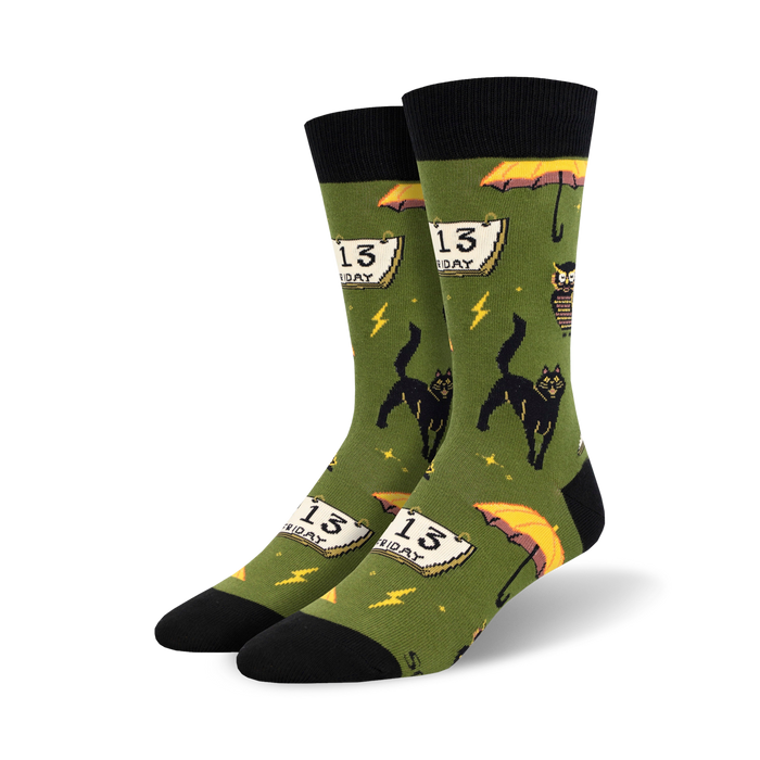 Pair of crew socks in olive green and orange, showcasing a fun, pixelated design of black cats, Friday the 13th calendars, and yellow umbrellas.