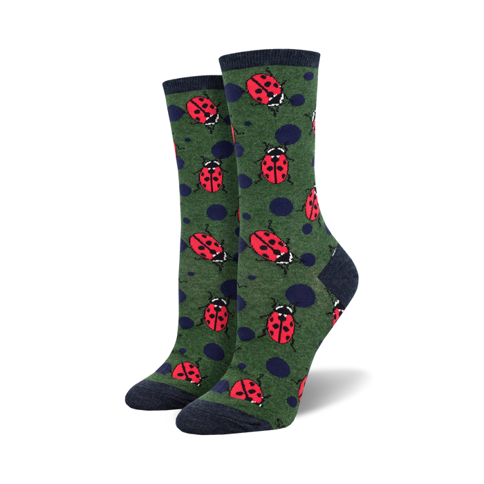Pair of women's crew socks. Green background with red ladybugs and navy blue polka dots.  Dark navy blue cuffs. }}