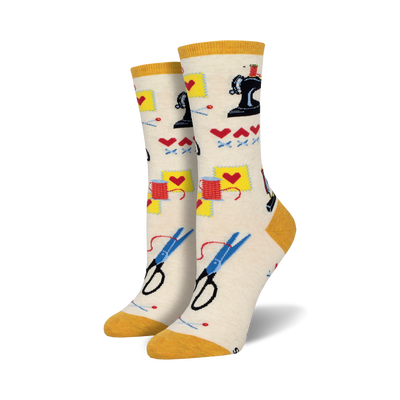Cream crew socks with a sewing-themed pattern: sewing machines, scissors, thread, and hearts. Yellow cuff.