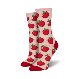 Close-up of a pair of blush pink crew socks with a red apple pattern and red cuffs.