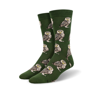 Pair of crew socks; olive green with repeating burrowing owl pattern. Owls are brown, white, and beige.