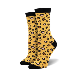 Lifestyle product shot of the yellow leopard print bamboo socks on a model's feet.