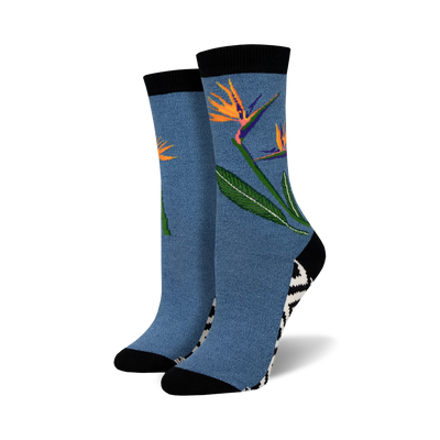 Pair of crew socks in blue featuring a bird-of-paradise flower design.  Black and white zig-zag pattern at the ankle. Soft bamboo.