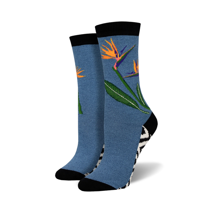 Pair of crew socks in blue featuring a bird-of-paradise flower design.  Black and white zig-zag pattern at the ankle. Soft bamboo.