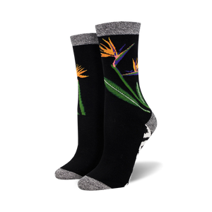 Close-up of a pair of black Birds of Paradise bamboo socks.  The socks feature a grey marl cuff and a black and white geometric pattern at the ankle.