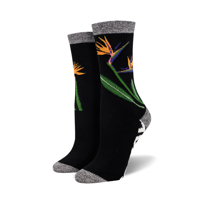 Close-up of a pair of black Birds of Paradise bamboo socks.  The socks feature a grey marl cuff and a black and white geometric pattern at the ankle.