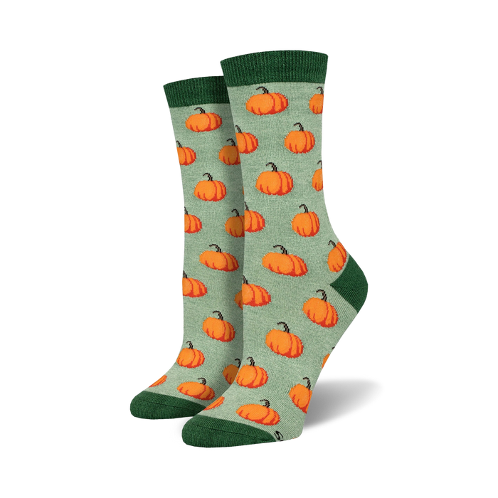 Pair of women's crew socks. Sage green background with a repeating pattern of orange pumpkins. Green cuff. }}
