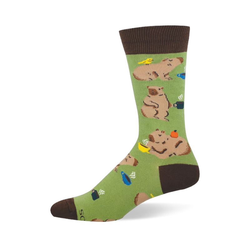 Light green crew sock featuring lounging capybaras, steaming coffee mugs, and a small yellow bird.