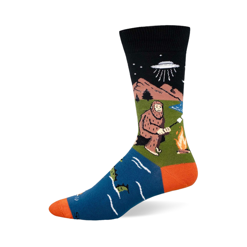 Crew sock with black top, blue foot, and orange heel/toe. Features Bigfoot by a fire, a UFO, and a swimming sea monster.