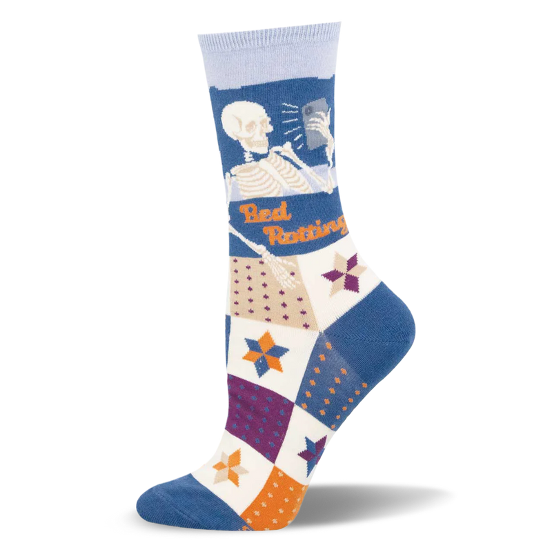 Crew sock with a skeleton looking at a phone and orange Bed Rotting text above a multi-colored patchwork quilt pattern.