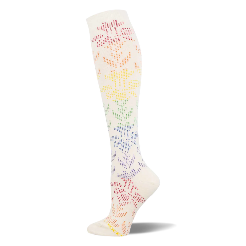 Cream knee-high sock showing a dotted floral lace pattern that shifts through a rainbow gradient from pink down to purple.