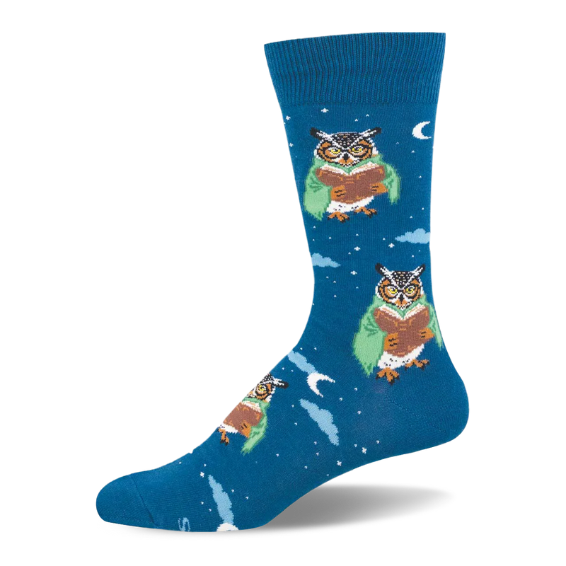 Deep blue crew sock patterned with owls in green cloaks reading books among white stars and pale clouds.