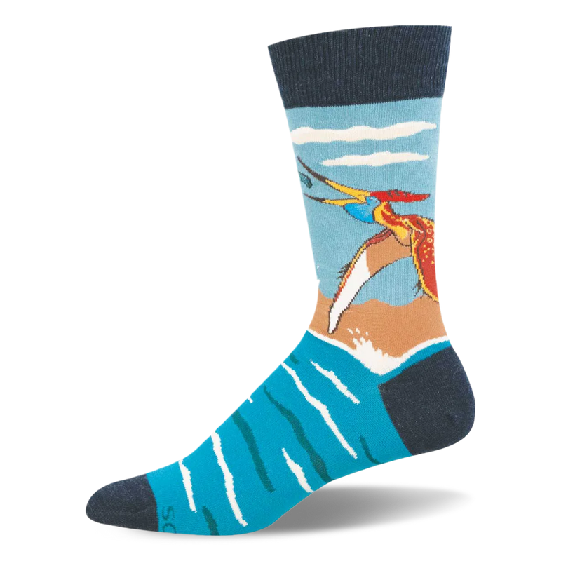 Crew sock showing a colorful flying pteranodon catching a fish over bright blue water and a sandy shore. Navy accents.