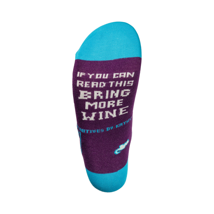 Close-up of the sock's heel, showing the text 'If you can read this, bring more wine' in a pixel font.
