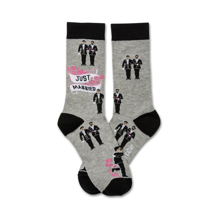 Two grey crew socks with black cuffs. The socks show illustrations of two grooms in tuxedos, a 'Just Married' banner, and pink roses. }}