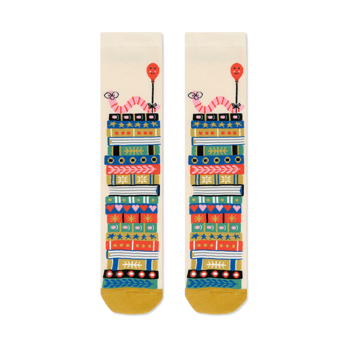 Cream crew socks with a whimsical design of colorful book stacks and pink worms holding balloons.