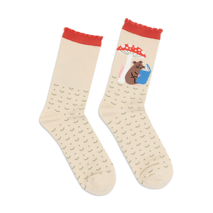 Cream crew socks with red accents. One sock features a mouse reading under a mushroom; the other is a repeating pattern.