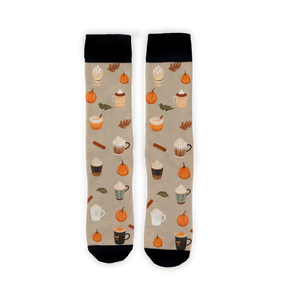 A pair of mid-calf socks with a pattern of coffee cups, pumpkins, and fall leaves on a beige background. The socks have black toes, heels, and cuffs.