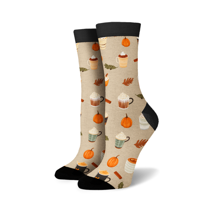 Pair of cream crew socks with a repeating pattern of pumpkins, coffee cups, and cinnamon sticks. Black cuffs.