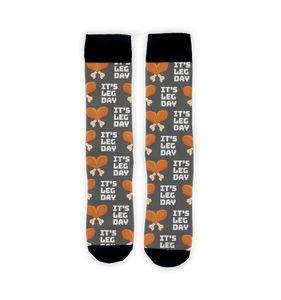 A pair of gray socks with a pattern of cartoon turkey legs and the words 