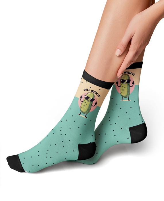 Lifestyle photo showing the 'Just Dill With It' socks on a person's feet. The socks are teal with a pickle design.