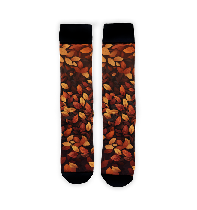 A pair of crew socks with an allover pattern of autumn leaves in orange, red, yellow, and brown on a black background.