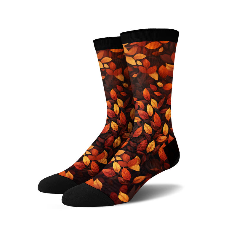 Pair of crew socks with an autumn leaves print. The socks are predominantly dark brown with orange and red leaves.