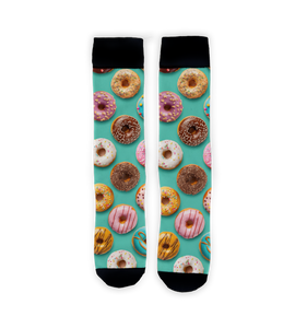 A person's legs are shown from the knees down. They are wearing socks with a pattern of various kinds of donuts on a blue background. The person's hand is lightly touching the top of one sock.