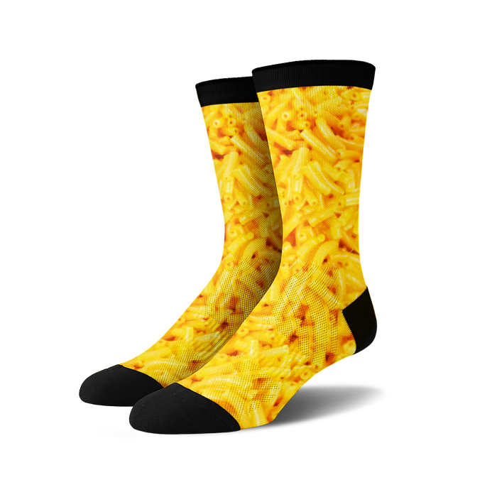 Pair of crew socks with an all-over print of macaroni and cheese in shades of yellow and black.