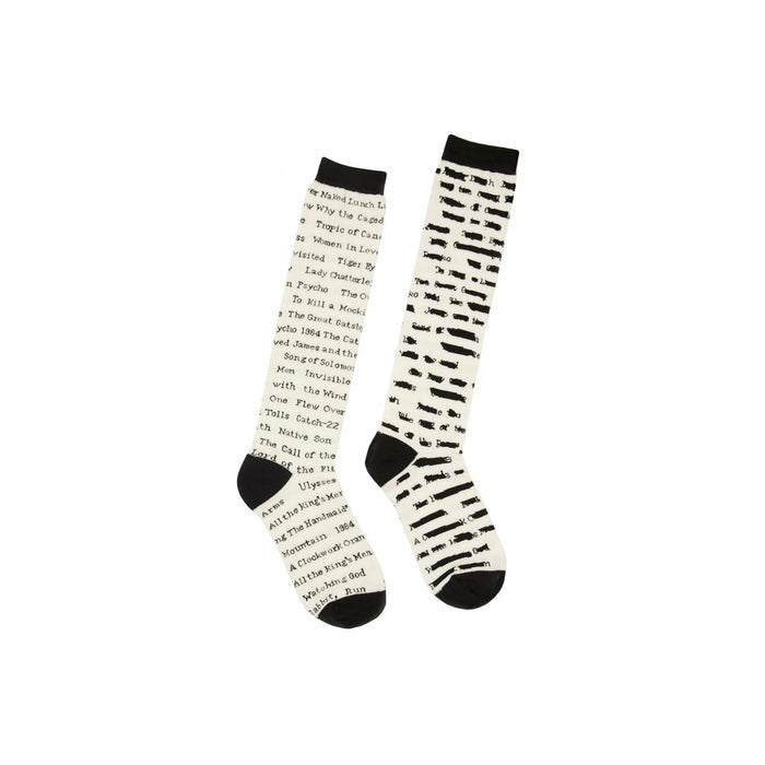 Pair of cream knee-high socks with black text listing titles of banned books. A literary-themed design for book lovers. }}