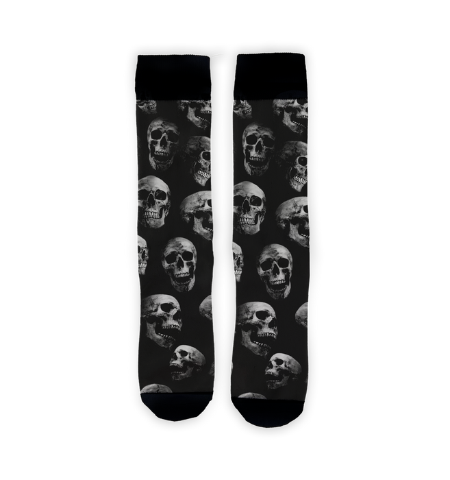 Flat lay showcasing a pair of black crew socks with a skull pattern.