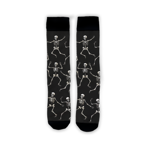 Flatlay image showing a pair of black 'Dead Man's Party' socks with dancing skeletons.