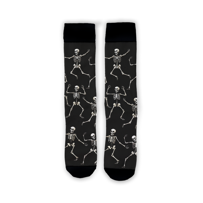 Flatlay image showing a pair of black 'Dead Man's Party' socks with dancing skeletons.