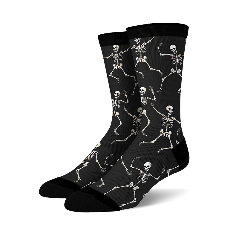 Pair of black crew socks with a fun all-over print of dancing skeletons in off-white.