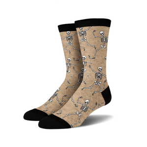 Pair of tan crew socks with a fun all-over print of dancing skeletons in off-white.
