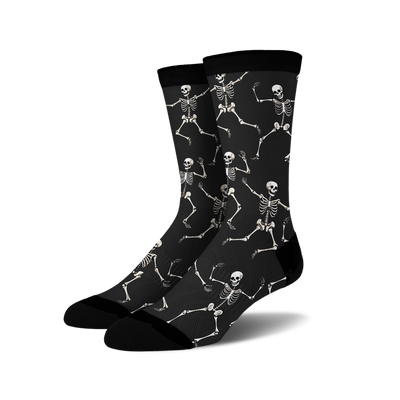 Pair of black crew socks with a fun all-over print of dancing skeletons in off-white.