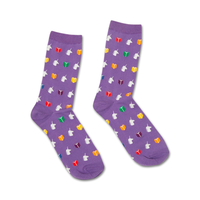 Pair of purple crew socks featuring a whimsical pattern of white unicorns reading rainbow-colored books. }}