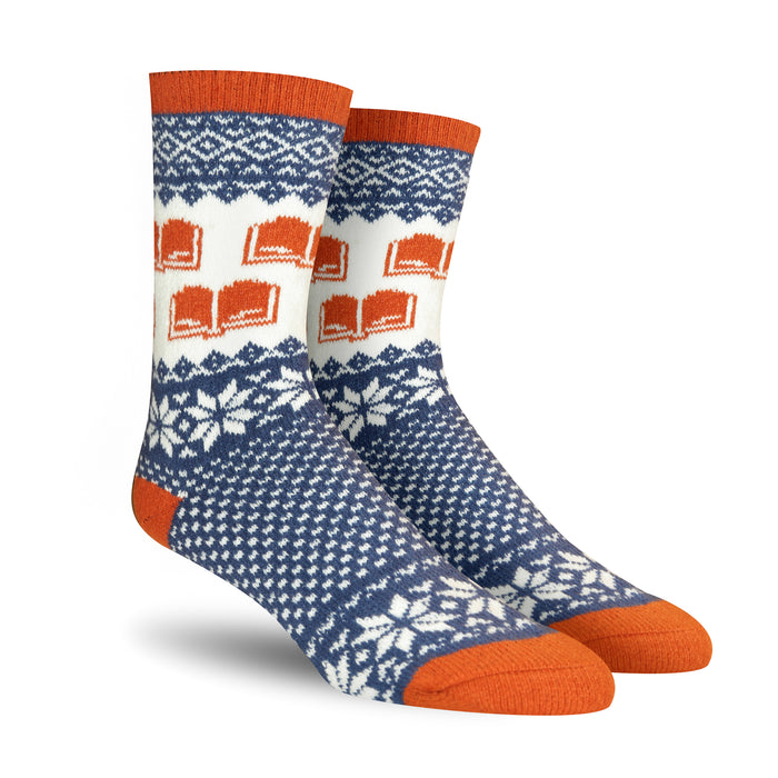 Pair of crew socks in navy blue, white, and burnt orange. Features a Fair Isle pattern with snowflakes and repeating book designs. }}