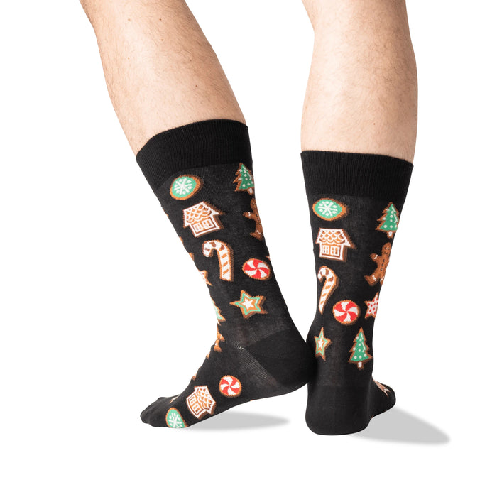 Close-up of a person's legs wearing black Christmas Cookie socks.