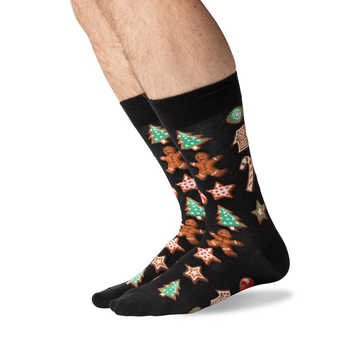 Person's legs wearing black Christmas Cookie socks, shown from the side.