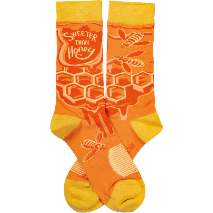 Crew socks in orange and yellow. Feature a honeycomb pattern, dripping honey, and bees. Text reads 'Sweeter Than Honey'. }}